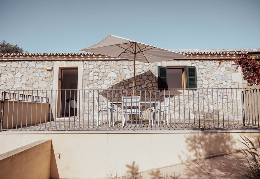 Terrasse des Familienappartements Außenterrasse mit Tisch, Stühlen und Sonnenschirm